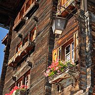 Gevel van traditioneel houten huis / chalet versierd met oude ski's in het Alpendorp Grimentz, Wallis, Zwitserland
House front of traditional wooden house / chalet decorated with old skis in the Alpine village Grimentz, Valais, Switzerland